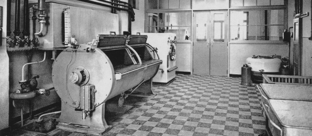 Bild aus der Buanderie/Wäscherei vun der Zithaklinik. Am Ufank vun der Klinik ass nach ganz vill Textil (Bettgezei, Handdicher), Botztextilien,Torschongen, Riddoen …), Verbandsmateriel, Operatiounsdicher an Schutzkleedung vun den Soignants an Dokteren , ob der Hand gewäscht gi oder an groussen Deppen ausgekacht gi. D’Textilien woren net aus Synthetik. D’Klinik hat och eng eegen Bitzerei wou aus Meterwuer/Ballen all méiglech an néideg Textilien déi an der Klinik gebraucht goufen, geschneidert gi sinn. Oft hunn hei, ënnert der Leedung vun enger Uerdensschwëster, Dammen hiert Handwierk geleiert a kënnen selbststänneg schaffen.Des Wäscherei ass déi 3. Generatioun, an schonns modern Maschinnen sinn zum Assatz komm. Si ass duerno 2 mol vergréissert gi. Haut gëtt d’Wäsch vu Baussen traitéiert an geliwwert. Vill Textilien sinn och duerch Einmalmaterial ersat (Operatiounsdicher an Schutzkleedung). D’Bild ass vum Paul Kutter Fotograph zu Letzebuerg