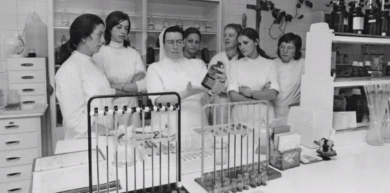 Bild aus dem Laboratoire vun der Zithaklinik.Mir gesinn hei eng Schoulschwester( Schwëster Marie Etienne) déi Soignantsschülerinnen weist wei Verdënnungen vun Laboratoireflessegkeeten gemaach gi. Di mäscht Laboratoireennersichungen sinn manuell gemaach gi. Verschidden Analysen sinn nëmmen 1-2 mol an der Woch gemaach gi.All Soignants huet missten déi normal Wäerter aus dem Blutt an dem Urin kennen, an déi mäscht Analysen verstoen an maachen kennen.Mir gesinn hei eng sougenannten Bludsenkungsapparatur wou gekuckt gëtt ob der Patient eng Infektioun huet. Spéider konnt eng Soignante sech am Fach Laboratoire spezialiséieren an am Laboratoire schaffen. Haut sinn déi mäscht Analysen voll automatiséiert. Vill Analysen kennen och vum Patient selwer gemaach gi.(Bluttzockerwäerter, Gerennungswerter, Härzwerter...). D’Bild ass vum Jean Weyrich Fotograph am Luxemburger Wort