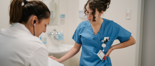 Foto eines Arztes und einer Pflegekraft um einen Patienten im Zimmer