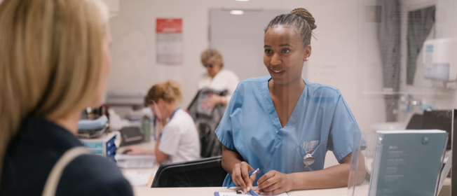 Foto einer Patientin am Aufnahmeeingang des Kirchberg-Krankenhauses mit einer Pflegerin