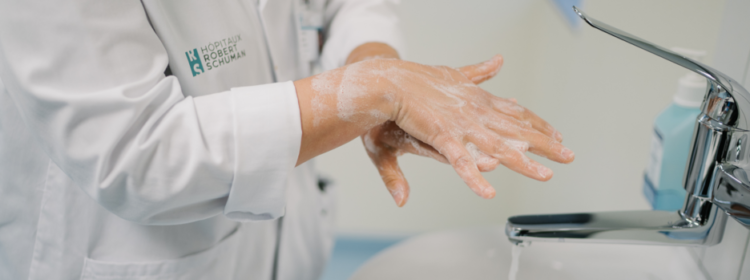Photo d'un médecin HRS qui se lave les mains au robinet avec de l'eau et du savon